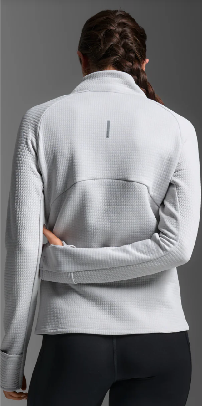 Lady wearing a light gray checkered jacket on a gray background