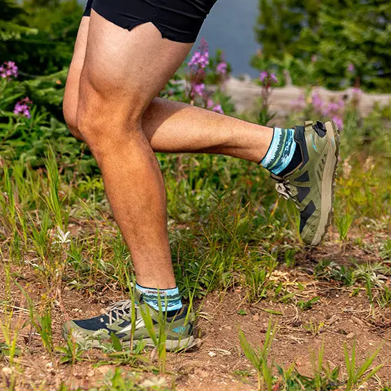 Person running on a trail with green shoes and socks