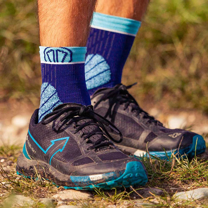 Close-up of black running shoes with blue accents on a natural outdoor background