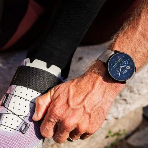 Close-up of two hands holding each other with a focus on a smartwatch.