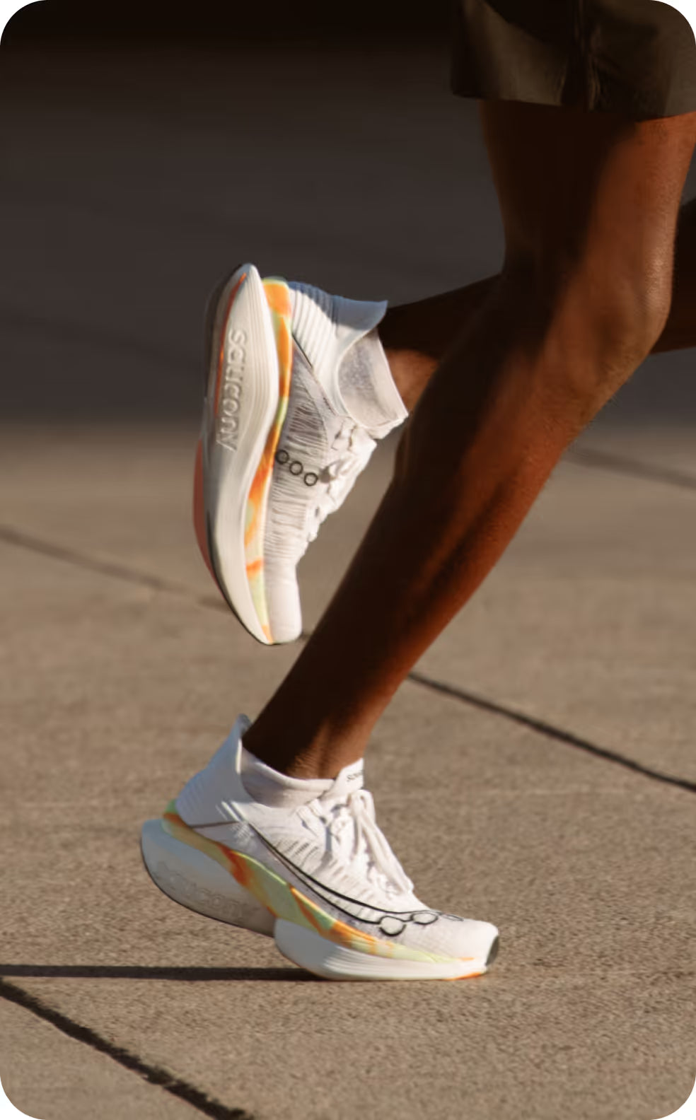 Person running on a road wearing white sneakers with orange accents